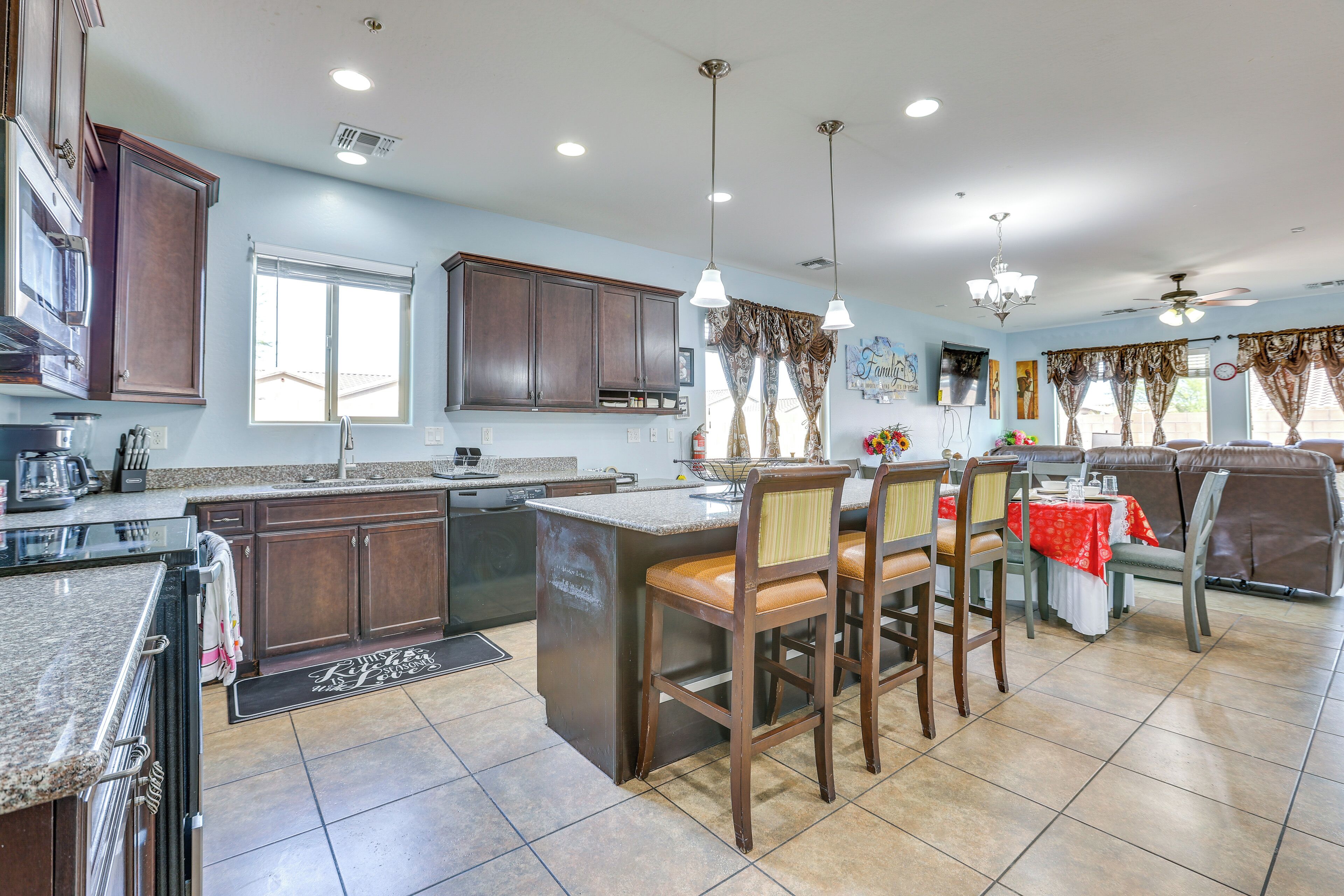 A spacious kitchen with a large island, dark wooden cabinets, and a dining area with a booth.