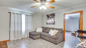 A living room with a sectional sofa, a ceiling fan, and a wooden floor. - Quiet & Cozy Rembert Home ~ 9 Mi to Air Force Base (Rembert)