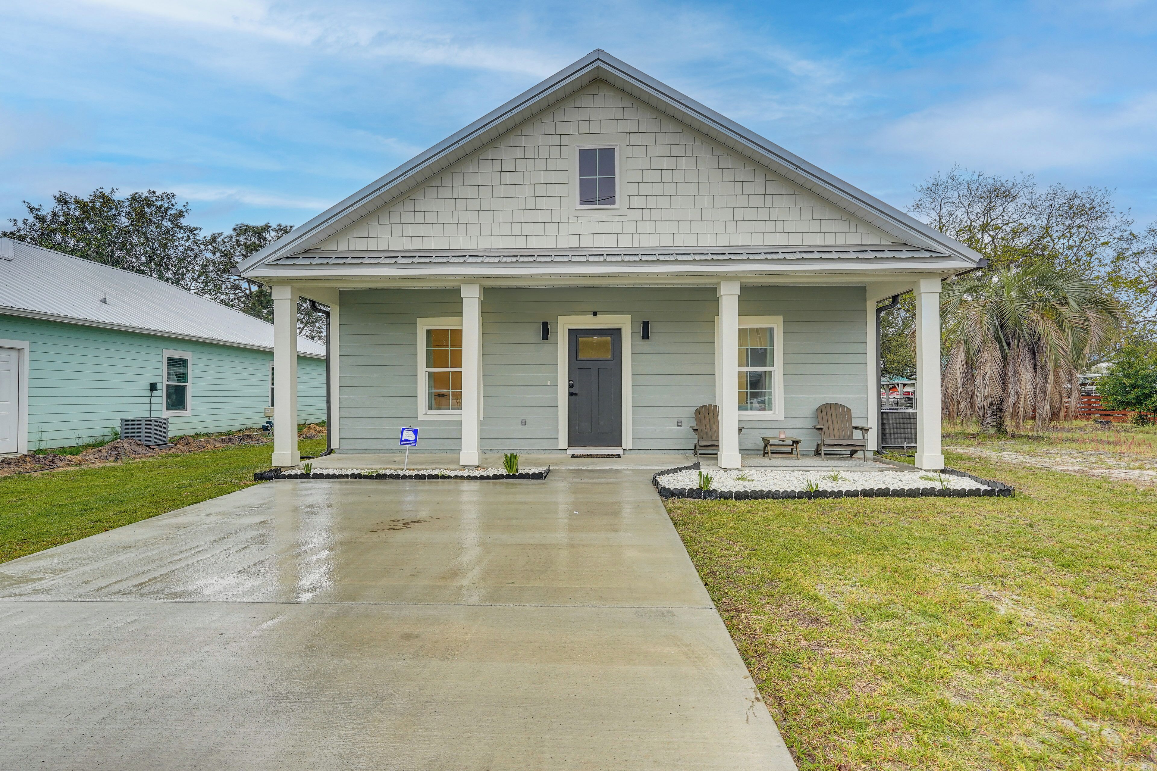 A single-story house with a front porch, a garage, and a driveway.