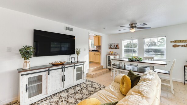 A modern living room with a sofa, TV, and dining area. - 1 Mi to Dtwn Waco! Lovely Home w/ Fire Pit Table (Waco)