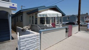 Un petit bâtiment d’un seul étage, doté d’un porche couvert et d’un petit espace patio.