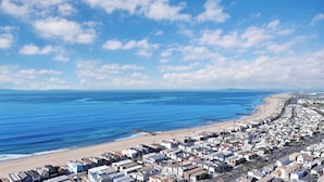 A coastal residential area with a beach and a row of houses along the shoreline. - 223 34th St A | Beautiful beach house, 2 blocks to the sand (Newport Beach)