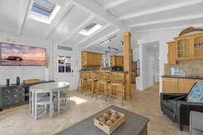 A spacious living area with a dining table, kitchen, and a view of the beach. - Lower Unit, Close to Restaurants, and Shopping (Newport Beach)
