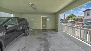 Autotalli, jonka sisällä on parkissa auto, ja jossa on ovi, jonka yläpuolella lukee ”VARATTU PAIKKA A”, sekä kyltti, jossa lukee ”VARATTU PAIKKA B”.