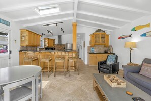 A spacious living area with a kitchen, dining table, and seating.