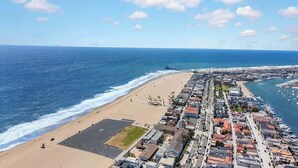 Eine Küstenstadt mit Strand, Yachthafen und Wohngebäuden.