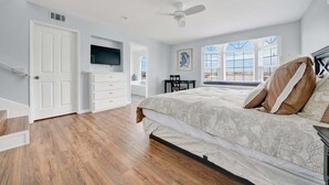 Un dormitorio con cama, televisión, escritorio y silla.