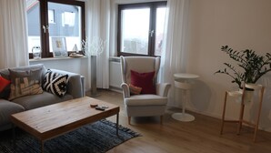 A living room with a sofa, armchair, coffee table, and a small side table.