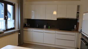 A modern kitchen with white cabinets, a black countertop, and a built-in oven.