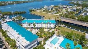 Un complexe hôtelier comprenant plusieurs bâtiments, un port de plaisance et une grande piscine.