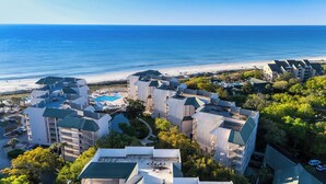 Een resort met meerdere gebouwen, een zwembad en uitzicht op het strand.