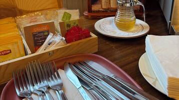 A table set with cutlery, napkins, and a bottle of Miel de Lavande.