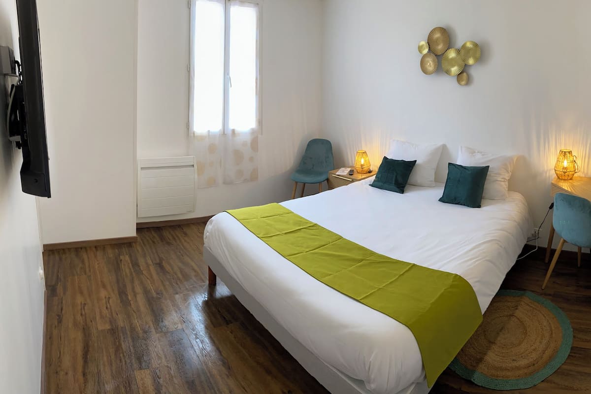 Une chambre d’hôtel avec un lit, un bureau et une chaise.