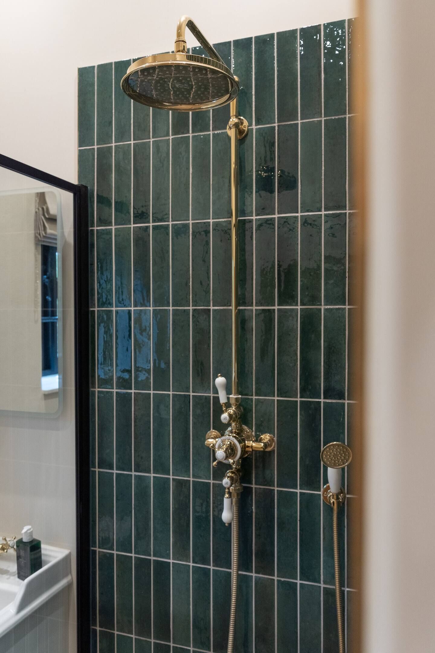 Ein Badezimmer mit Dusche, Waschbecken und Spiegel.