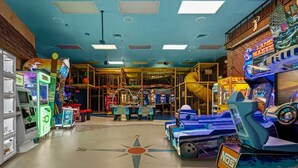 Un salón de juegos recreativos con diversas máquinas y una zona de recreación central.