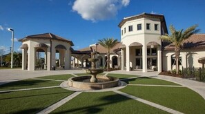 Stunning building with a central fountain and manicured lawn, featuring a blend of traditional and modern architecture.