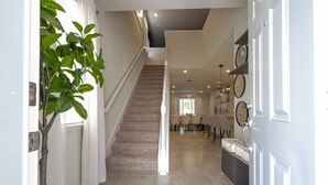 A staircase leading to a dining area with a plant on the left.