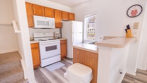A modern kitchen with wooden cabinets, white appliances, and a window providing natural light. - 4562 YR - Amazing 4 Bed Private Getaway (Kissimmee)
