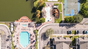 An aerial view of a resort with a swimming pool, sun loungers, a basketball court, and a tennis court. - 4562 YR - Amazing 4 Bed Private Getaway (Kissimmee)