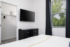 A bedroom with a bed, a TV mounted on the wall, a dresser, and a window with curtains. - 3236 TT Hub Townhome: 3BR, 3BA, Sleeps 8 (Bay Lake)