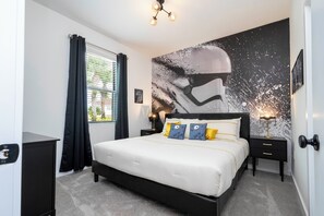 A modern bedroom with a large bed, black nightstands, a wall mural, and a window with curtains.