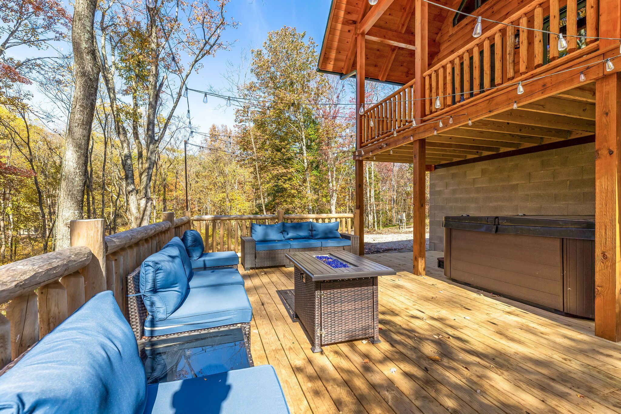 A wooden deck with outdoor seating and a hot tub.