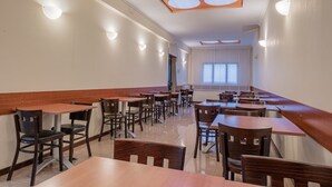 A spacious restaurant with long tables and chairs, a high ceiling with recessed lighting, and a view of the outdoors through large windows. - Hotel Monte Verde  (Rome)
