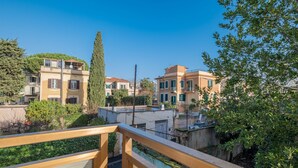 A residential area with multi-story buildings, a wooden balcony, and greenery. - Hotel Monte Verde  (Rome)