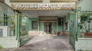 The entrance to Hotel Monteverde with a green facade, a glass door entrance, and a number 86 sign. - Hotel Monte Verde  (Rome)