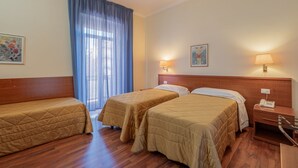 A hotel room with two single beds, wooden headboards, a large window with blue curtains, and two wall-mounted lamps. - Hotel Monte Verde  (Rome)