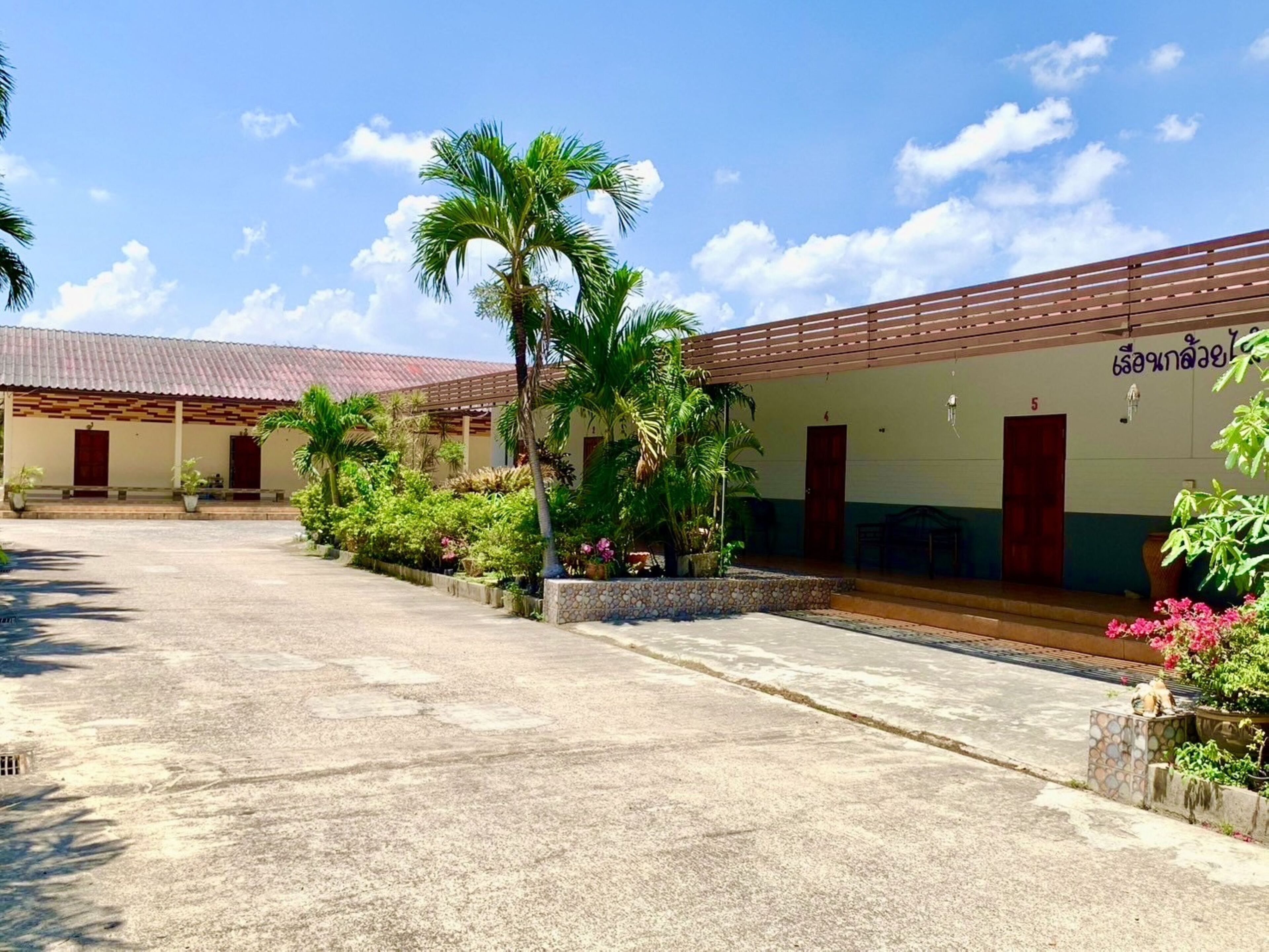 A building with a tiled roof, a covered walkway, and a paved courtyard.