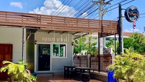 A restaurant with a covered outdoor seating area, a signboard, and potted plants. - Baan Kenpoo Resort (Phetchaburi)
