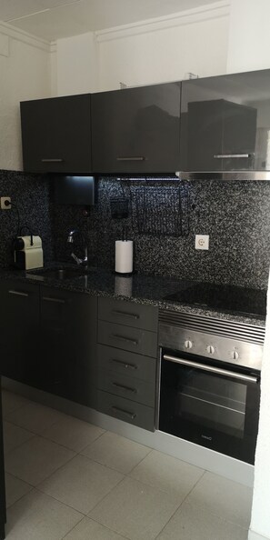 Enjoy cooking in this well-equipped kitchen with an oven, range hood, and sink island.