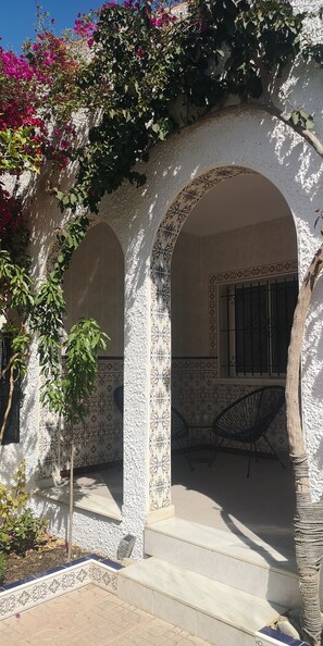 Stroll through the tranquil outdoor space, surrounded by lush greenery and intricate tile work.