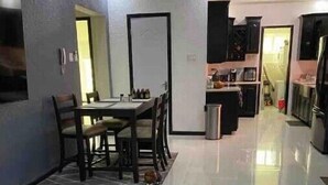 A modern living room with a dining area, a kitchen, and a small seating area with a coffee table. - Quiet , pool, gated,security (kingston 19)