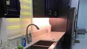 A kitchen with a sink, stainless steel cabinets, and a refrigerator. - Quiet , pool, gated,security (kingston 19)