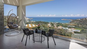 Un balcón con mesa y sillas, una hamaca colgante y vistas al mar y al paisaje.