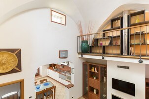 A spacious kitchen with modern appliances, a dining area with a glass table, and a living area with a flat-screen TV.