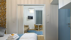 A hotel room with a bed, a desk, a chair, a TV, and a bathroom visible through an open door. - Visconti apartment (Roma)