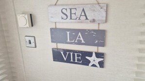 A wall with a wooden sign reading "SEA LA VIE" and a starfish decoration. - Inviting 2-bed Caravan on Combe Haven Holiday Park (St Leonards-On-Sea)