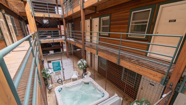 A wooden cabin with a hot tub, a fenced outdoor area, and a balcony. - Fall Line- Curate Telluride,Hot Tub,Remodeled, Walk to Ski, Center of Town, Park (Telluride)