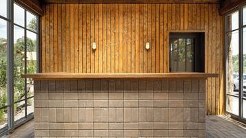 A wooden reception desk with a brick base, large windows, and a door.