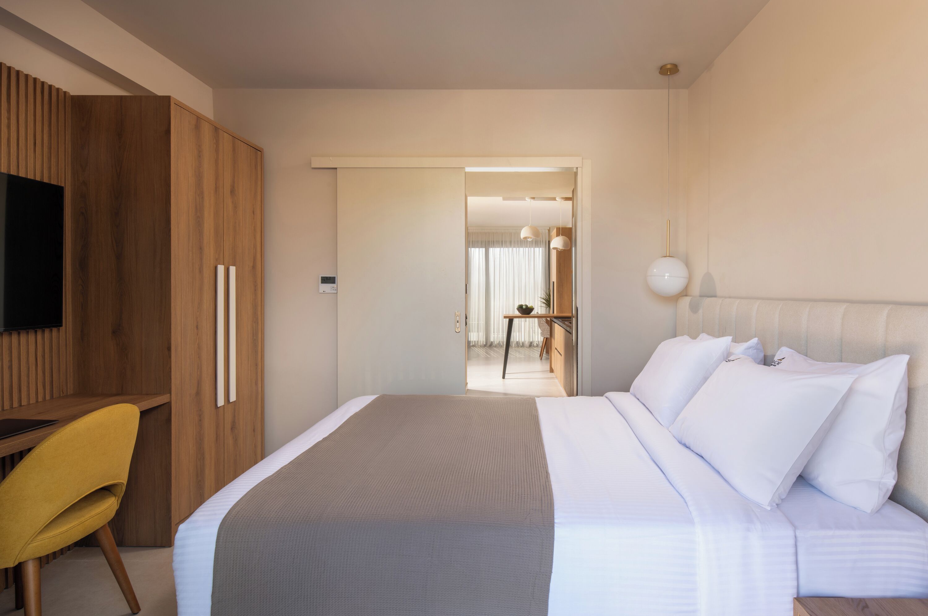 Een hotelkamer met een bed, een bureau, een stoel en een televisie.