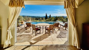 Eine Terrasse mit Pool, Gartenmöbeln und Blick auf die Landschaft.