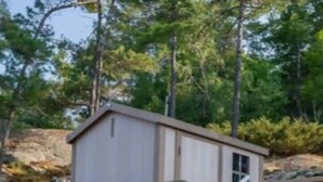 Une terrasse en bois avec des rampes en métal menant à une petite structure ressemblant à un chalet.