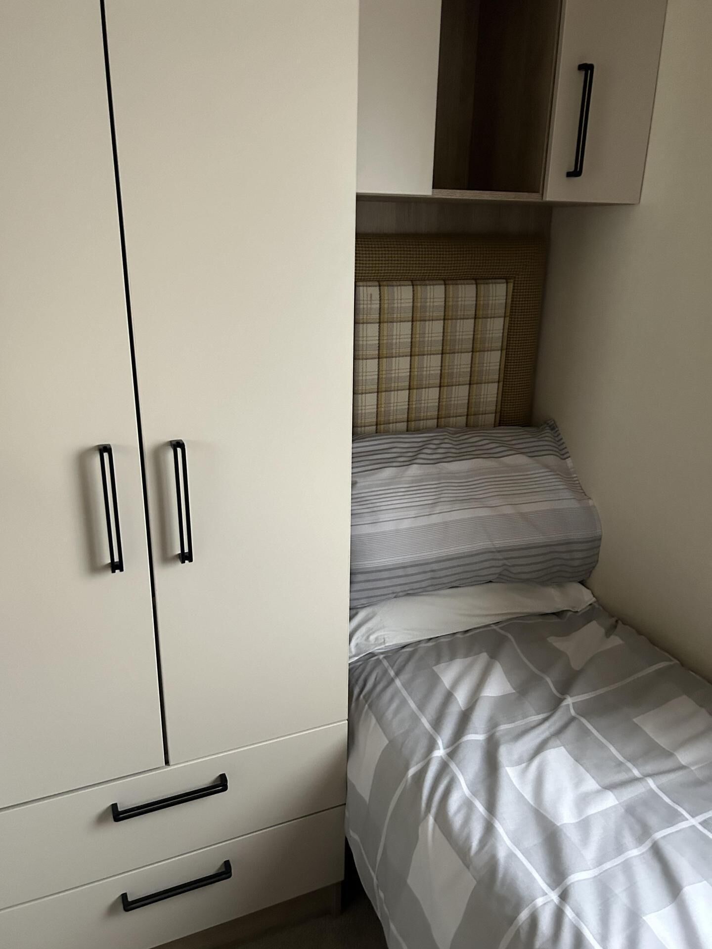 Un dormitorio con cama, armario y una pequeña alacena.