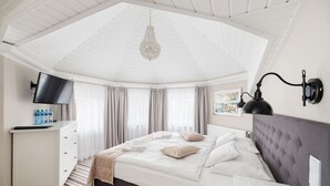 Un dormitorio con cama, escritorio, televisor y candelabro.