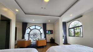 A hotel room with two beds, a TV, a coffee maker, and a view through a large window. - KSol Hotel & Apartment (Cam Ly - Da Lat)