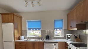 A kitchen with wooden cabinets, a dishwasher, a stove, and a microwave.