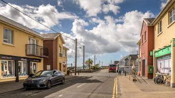 A street view with a salon, a red truck, and a bicycle.